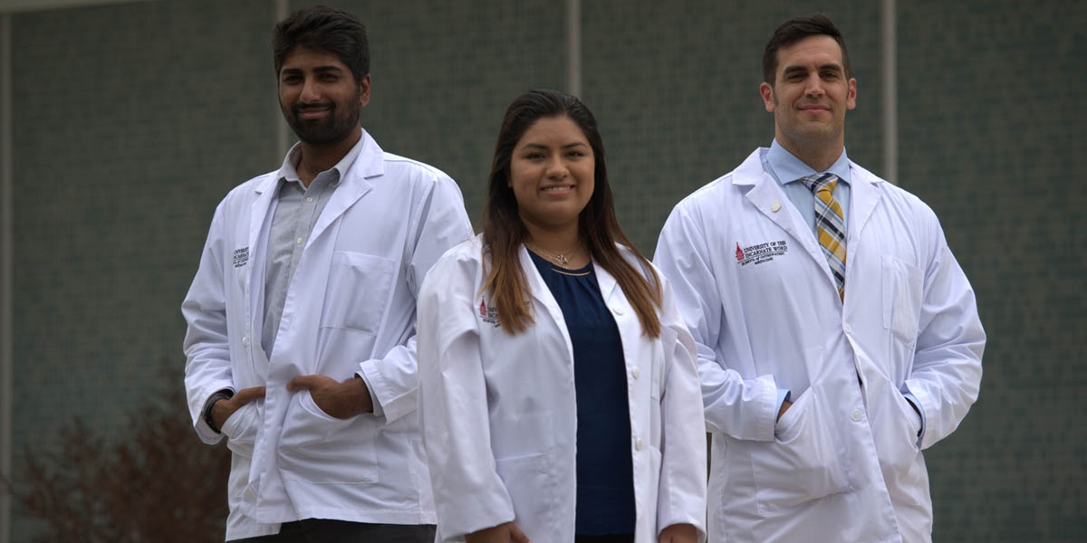 Three students with lab coats