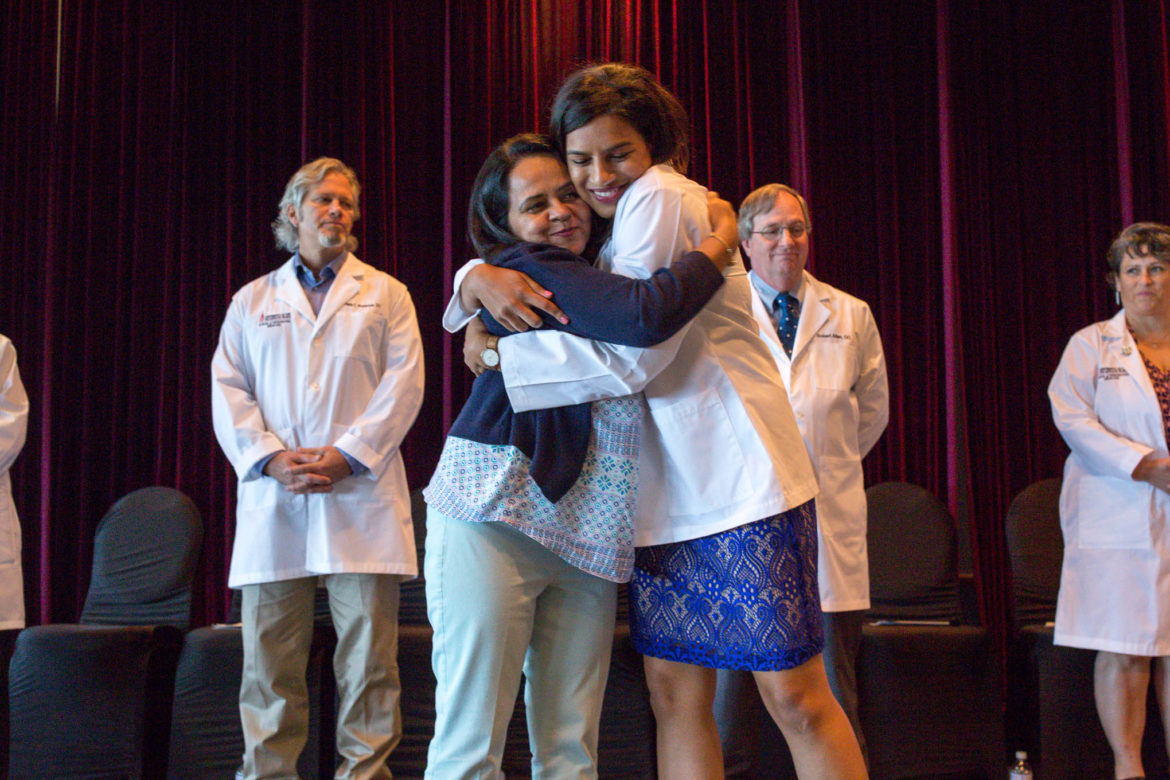 Maria Ahmad embraces her Aunt Asma Ahmad, MD following the presentation of her white coat during the ceremony.